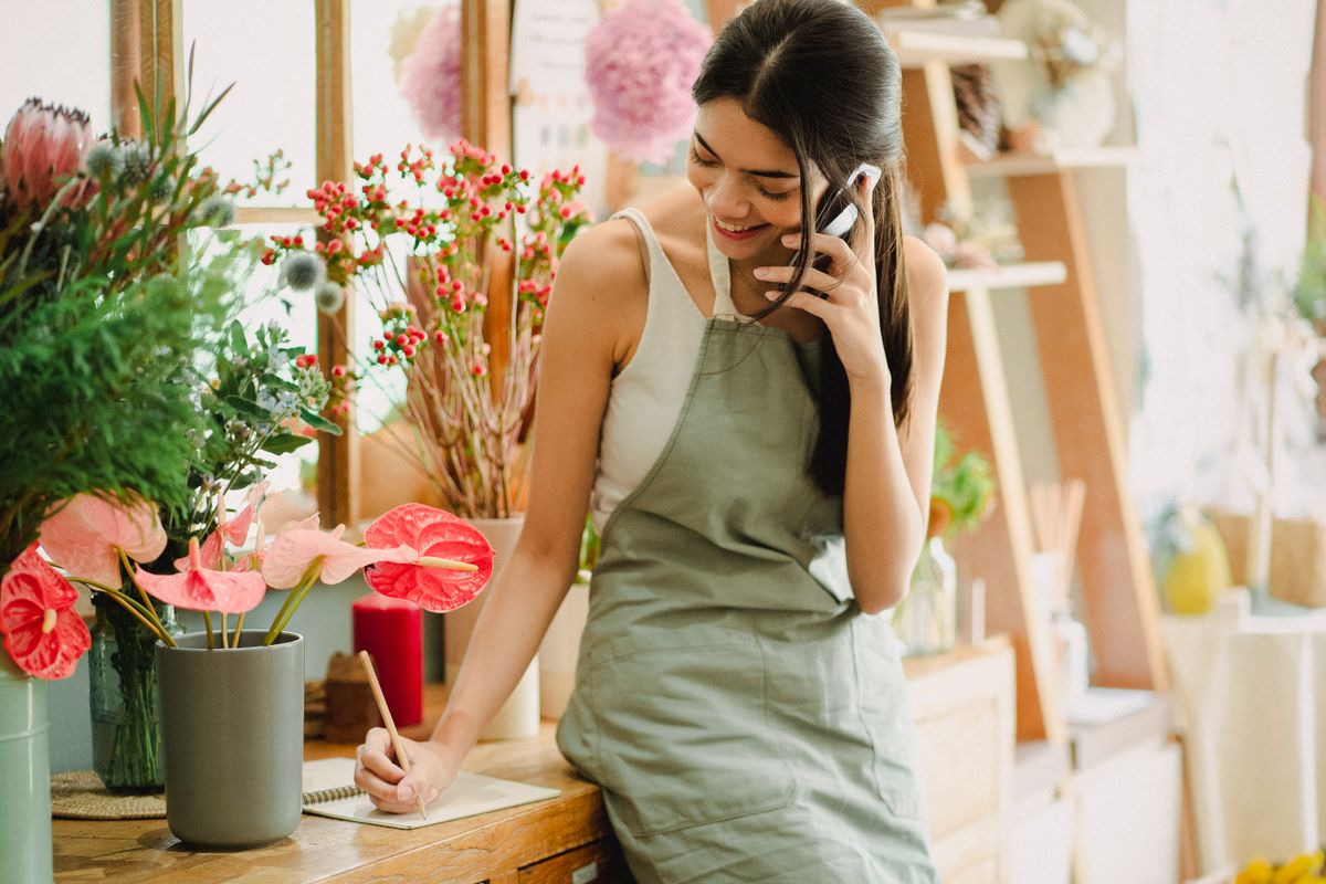 Commerçante indépendante au téléphone gérant la communication de sa petite entreprise