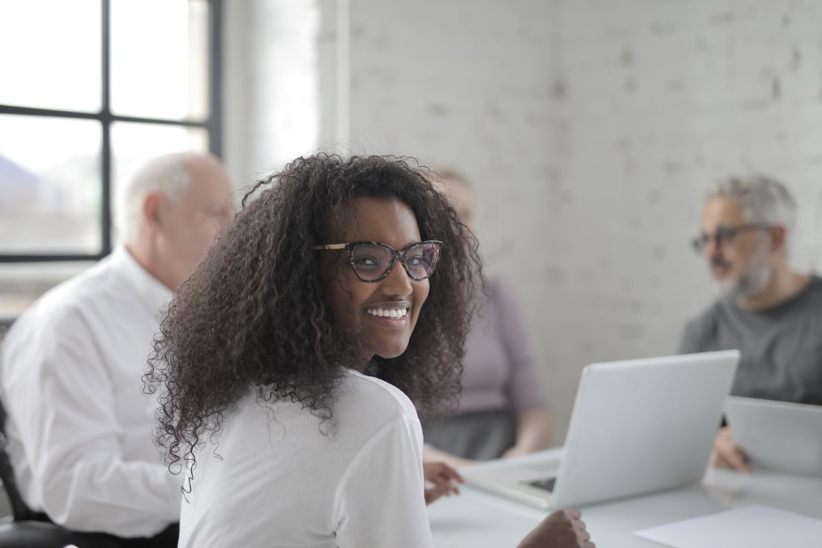 Réunion professionnelle discutant du choix entre déléguer la communication ou se former, ambiance de travail collaborative