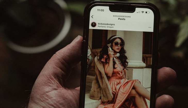 Main tenant un smartphone qui affiche une publication Instagram, illustration des carrousels et des contenus à publier