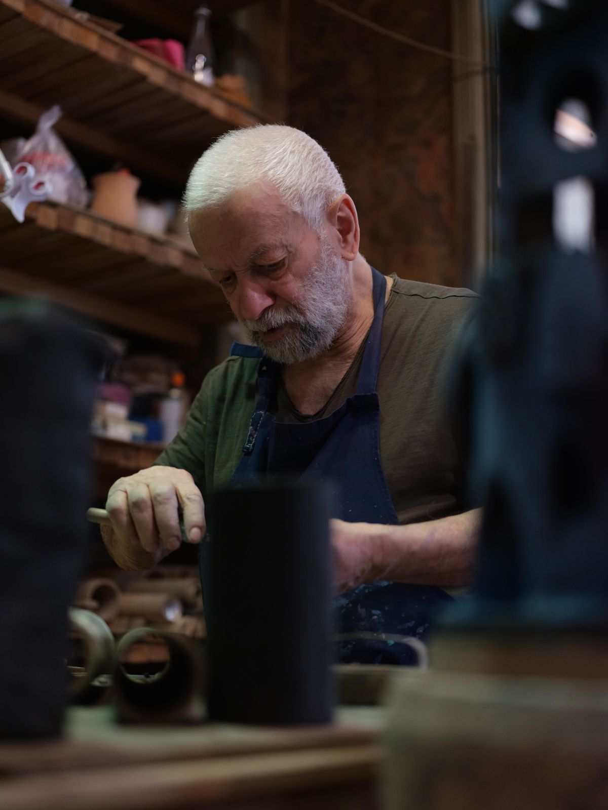 Artisan potier concentré sur son travail dans son atelier, exemple de savoir-faire qui nourrit le storytelling de marque